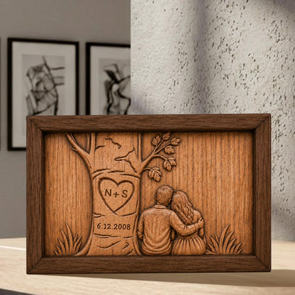 May include: A wooden plaque with a carved tree design, featuring a heart with "N + S" and the date "6.12.2008". The plaque depicts a couple embracing under the tree, all within a dark brown frame.