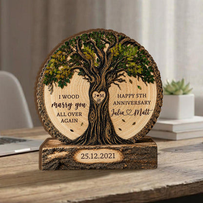 May include: A circular wooden plaque featuring a carved tree with green leaves, engraved with the text I WOOD marry you ALL OVER AGAIN, HAPPY 5TH ANNIVERSARY, Julia and Matt, and a heart with J M, set on a rectangular base with 25.12.2021.