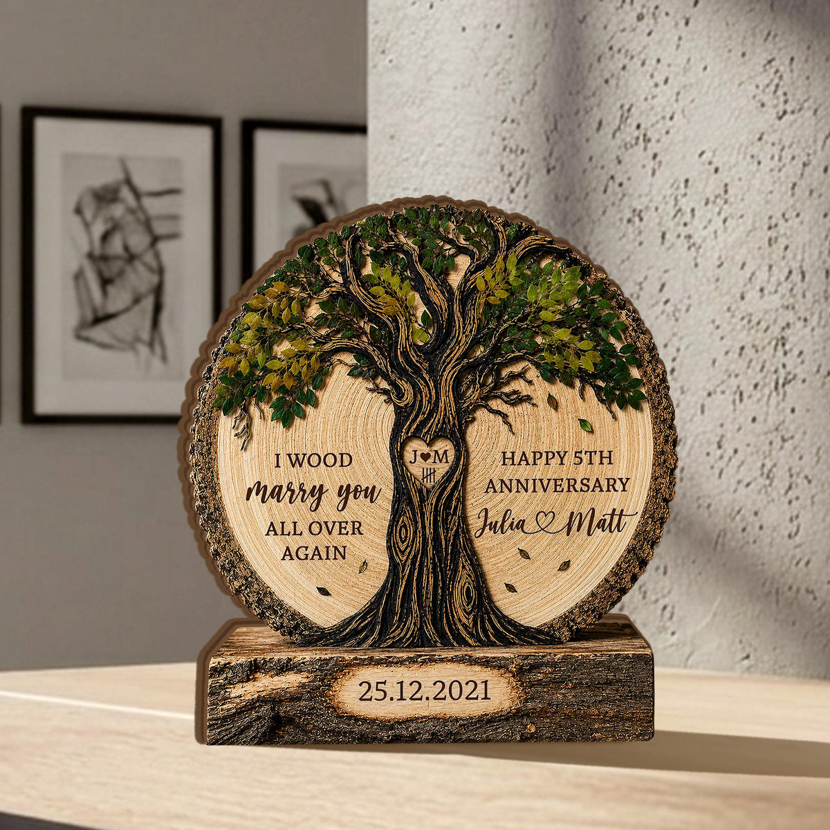 May include: A circular wooden plaque featuring a carved tree with green leaves, text reading I WOOD marry you ALL OVER AGAIN and HAPPY 5TH ANNIVERSARY Julia and Matt, a heart with J M, and a rectangular base with the date 25.12.2021 engraved on it.