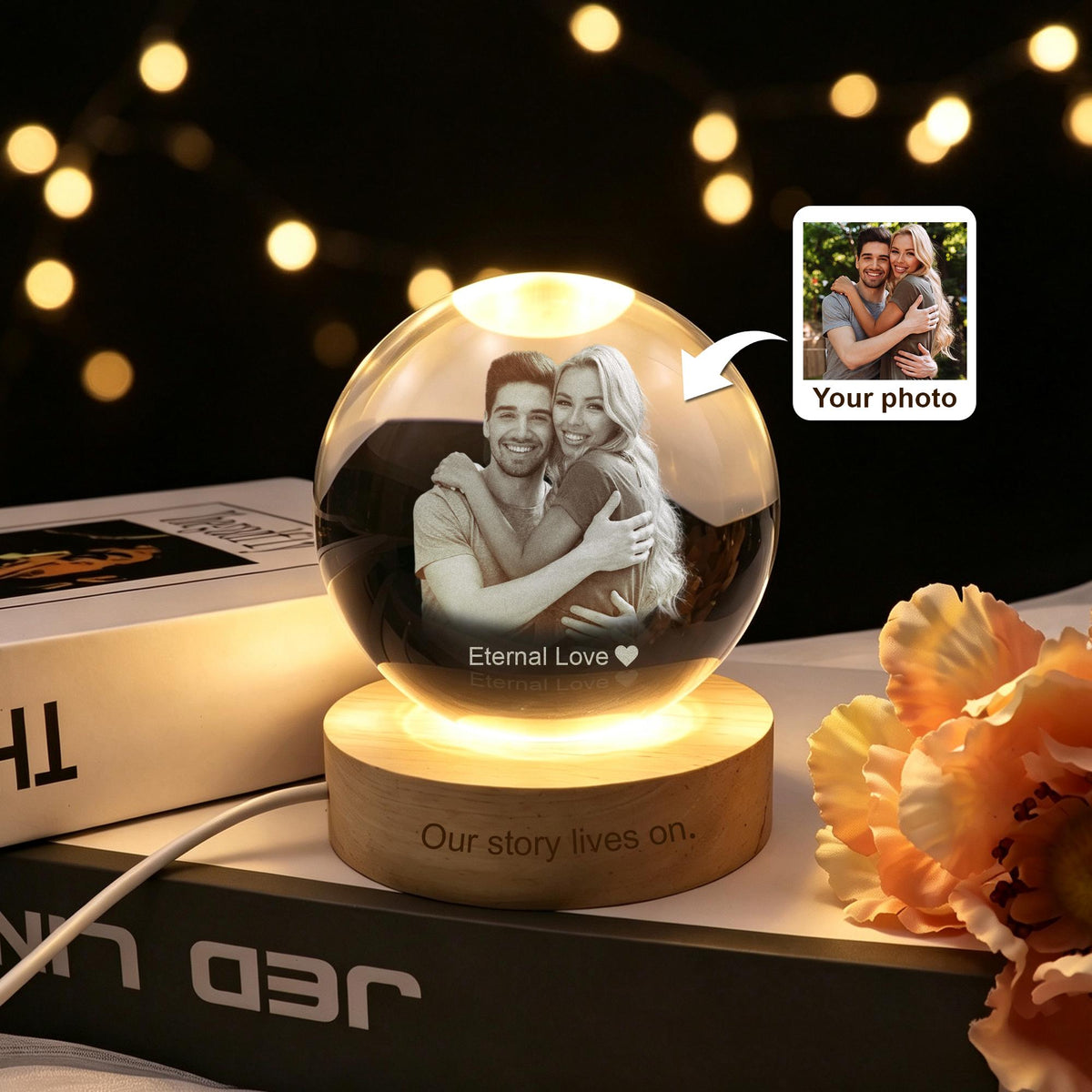 A clear glass sphere lamp featuring a laser-engraved photograph of a couple embracing inside. The sphere rests on a light-colored wooden base with the engraved text "Our story lives on." and the words "Eternal Love" below the photo.