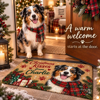 May include: A rectangular doormat featuring a printed illustration of an Australian Shepherd dog wearing a red and green plaid scarf. The mat includes the text "Christmas Kisses from Charlie" surrounded by pine branches, red berries, and gift boxes.