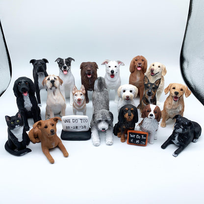 May include: A collection of dog figurines in various breeds and colors, including black, brown, white, and tan. Some figurines have their tongues out. Two signs read "WE DO TOO" with dates.