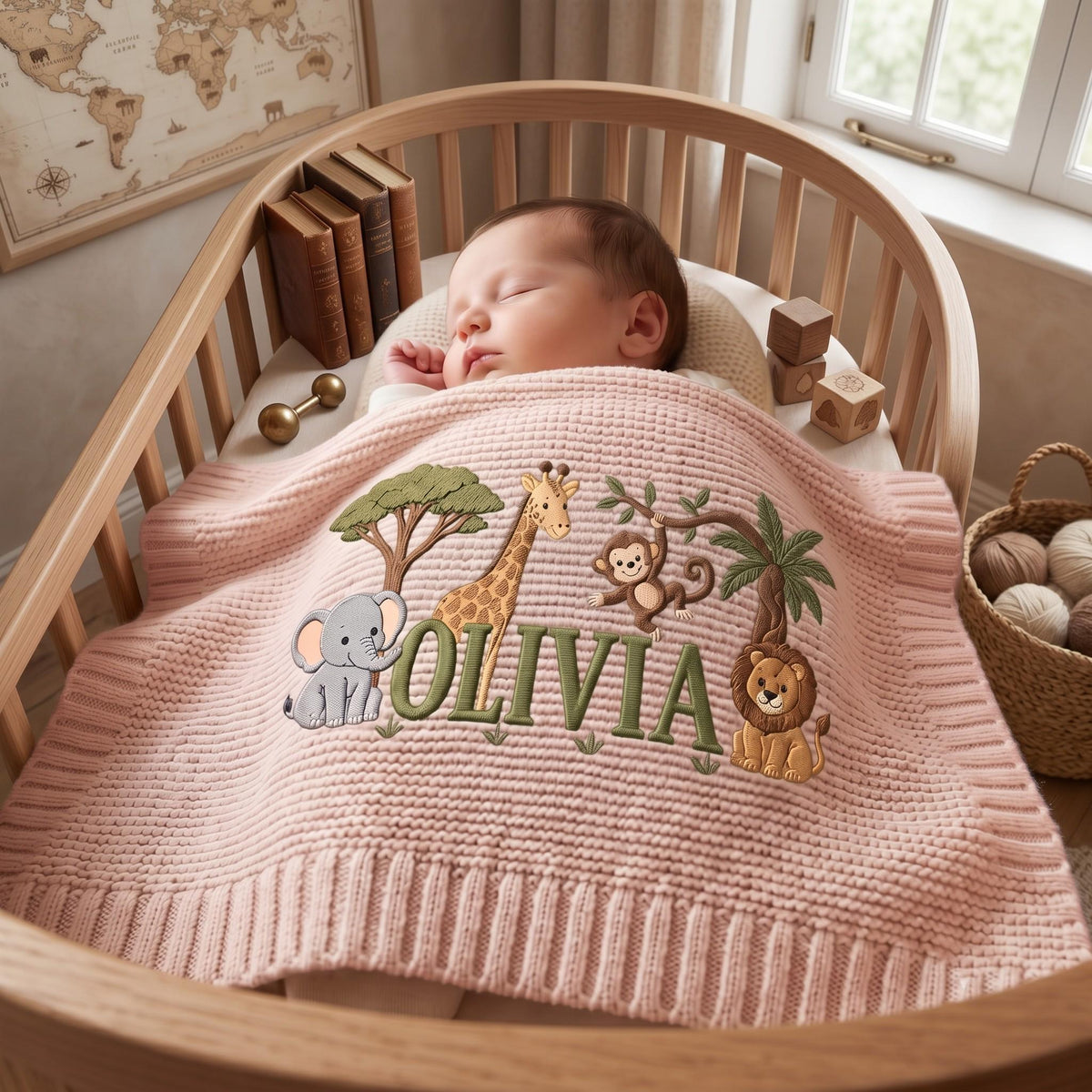 A soft, pale pink knitted baby blanket featuring an embroidered jungle scene with a gray elephant, a yellow giraffe, a brown monkey, and a lion. The name OLIVIA is stitched in large green letters across the center of the blanket.