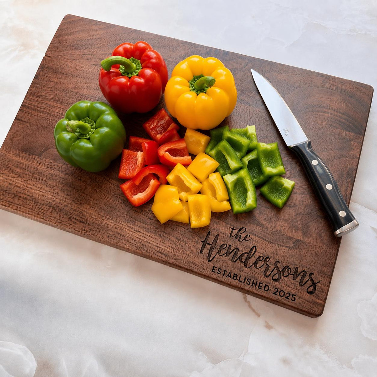 A wooden cutting board with sliced bell peppers and a knife on it, along with a personalized engraved nameplate.