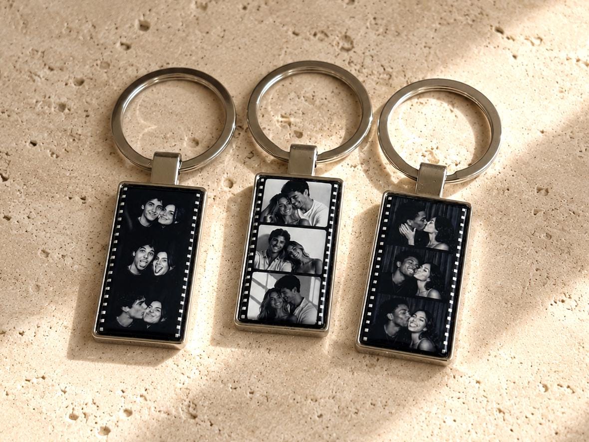 Close-up of epoxy-sealed film strip keychain with three portrait photo panels in polished silver metal frame