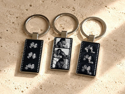 Close-up of epoxy-sealed film strip keychain with three portrait photo panels in polished silver metal frame