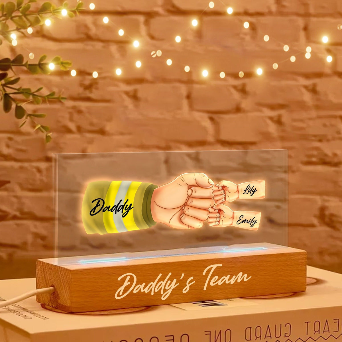 May include: A wooden base with a clear acrylic panel featuring a handprint design with the words "Daddy", "Lily", and "Emily" and the text "Daddy's Team" on the base.