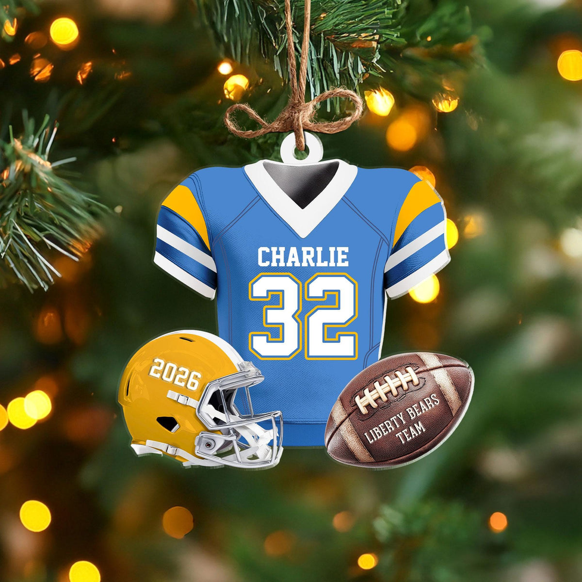 May include: A hanging ornament shaped like a light blue football jersey with yellow and white sleeves, featuring the name CHARLIE and number 32. Below are a yellow football helmet with 2026 printed on it and a brown football labeled LIBERTY BEARS TEAM.