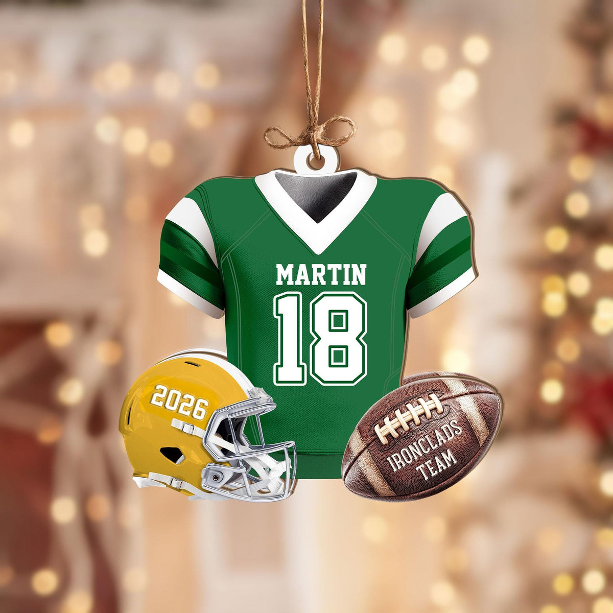 May include: A hanging ornament shaped like a green and white football jersey with the name MARTIN and number 18, accompanied by a yellow football helmet labeled 2026 and a brown football with the text IRONCLADS TEAM printed on the side.
