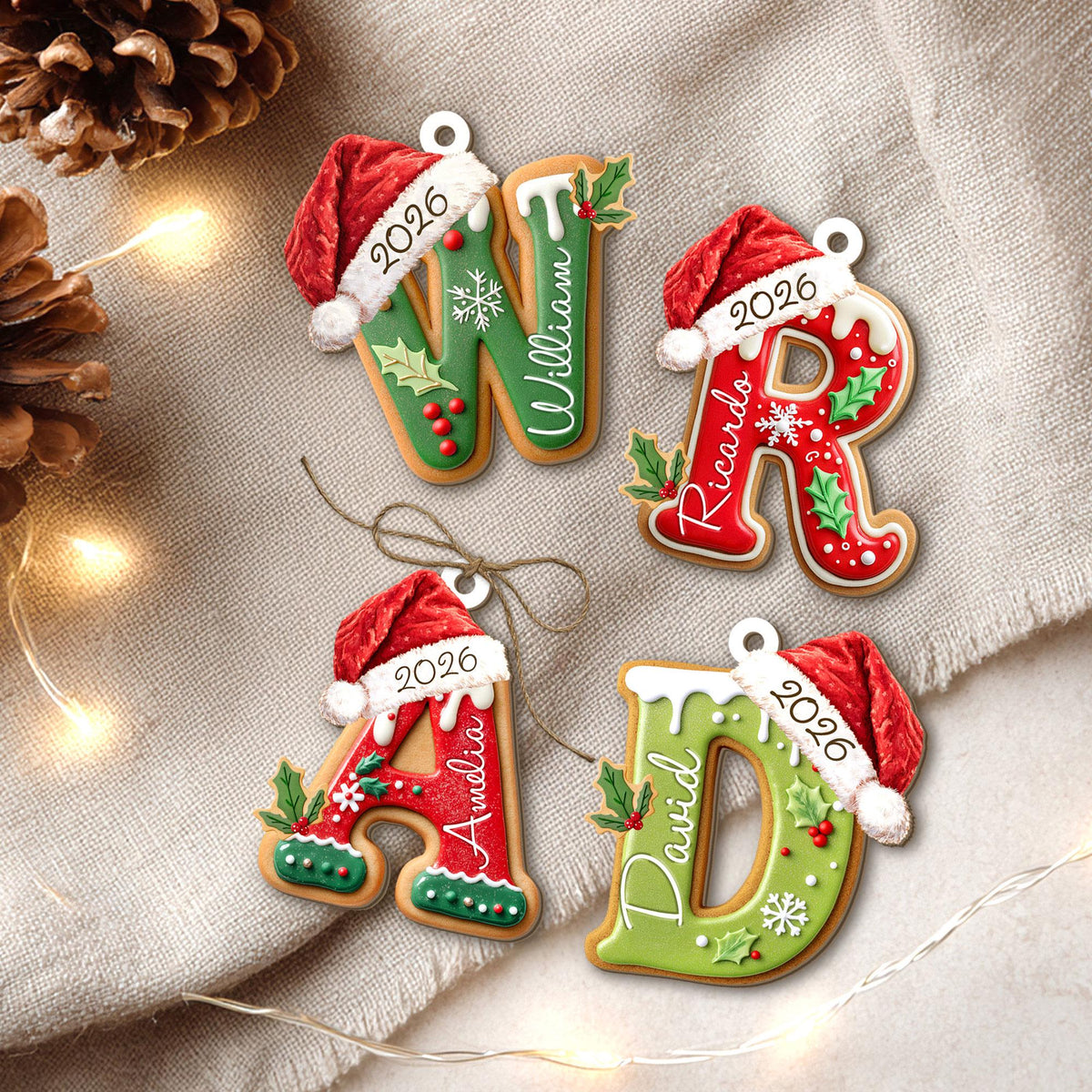 May include: Four letter-shaped Christmas ornaments in the shapes of W, R, A, and D. Each letter features a red Santa hat, white icing, holly leaves, berries, and snowflakes. The letters are personalized with the names William, Ricardo, Amelia, and David, and the year 2026.