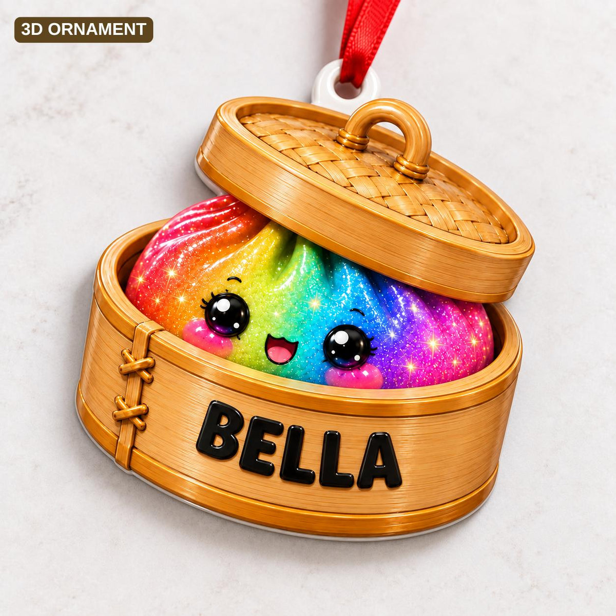 A 3D ornament shaped like a bamboo steamer basket containing a rainbow-colored, glittery dumpling with a smiling face. The side of the wooden-textured steamer is printed with the name BELLA in bold black capital letters.