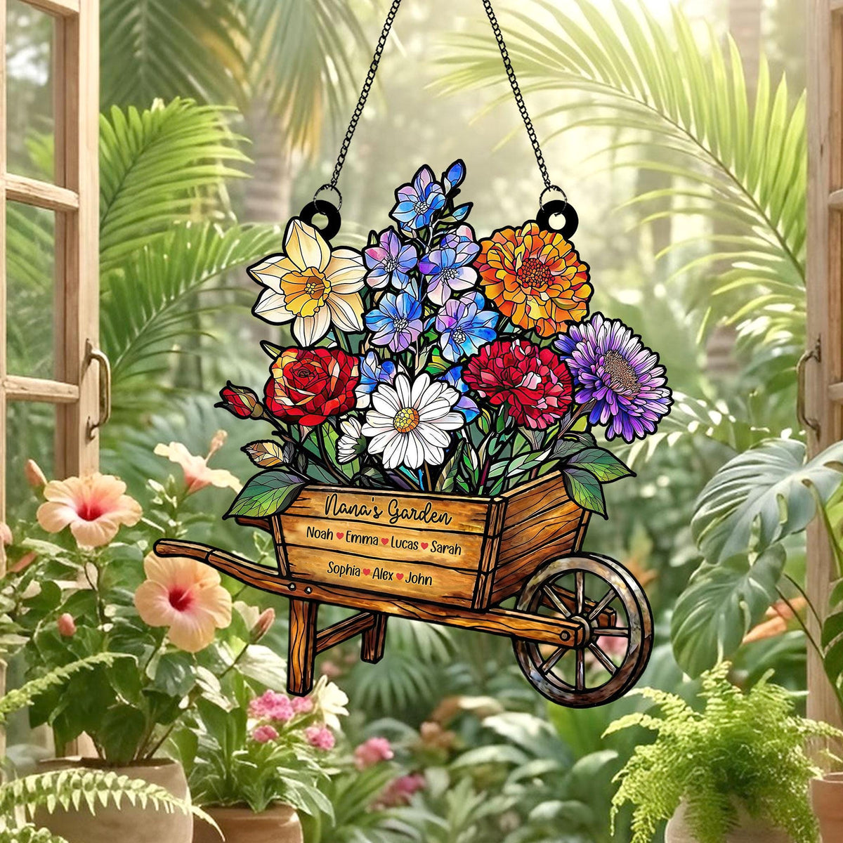 May include: A decorative garden sign featuring a wooden wheelbarrow overflowing with colorful flowers. The sign is suspended by a chain and includes the text "Nana's Garden" and several names. The flowers include red roses, daisies, and purple asters.