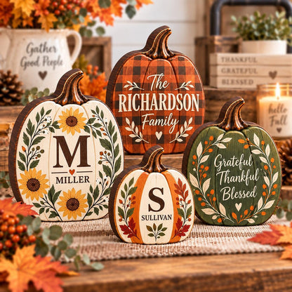 May include: Four decorative wooden pumpkins featuring autumn themes. One is white with sunflowers and the letter M, one is orange plaid with The Richardson Family text, one is small with the letter S, and one is green with Grateful Thankful Blessed text.
