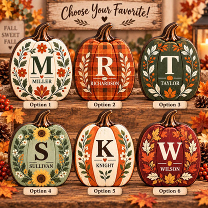 May include: Six decorative wooden pumpkin cutouts arranged in two rows. Each pumpkin features a unique seasonal design with a large central letter, a surname, and botanical accents. The designs include floral, plaid, and leaf patterns.