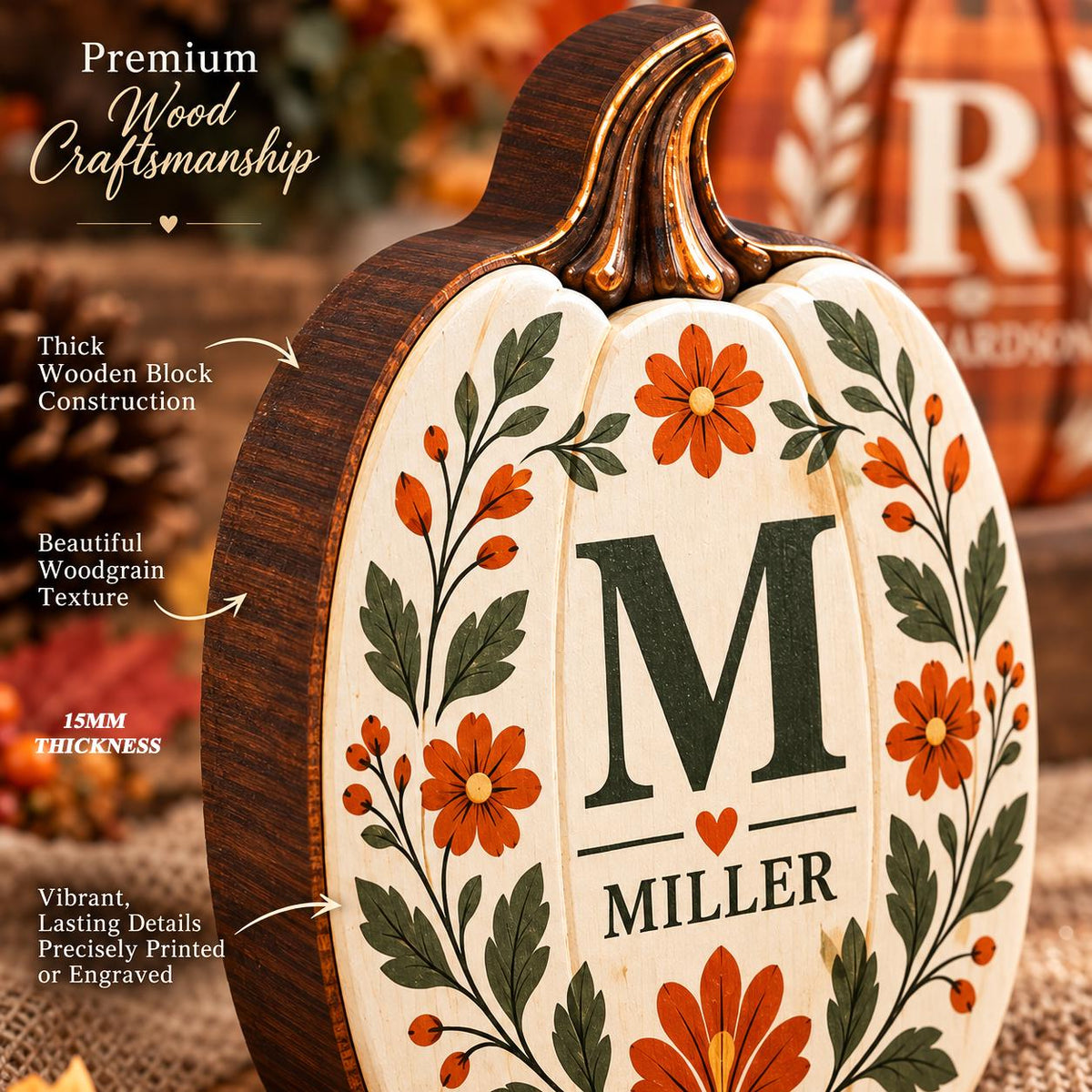 May include: A wooden pumpkin decoration featuring a cream-colored front with a dark green letter M, the name MILLER, and a small heart. The design includes orange flowers and green leaves. The side shows a dark woodgrain texture and 15mm thickness.