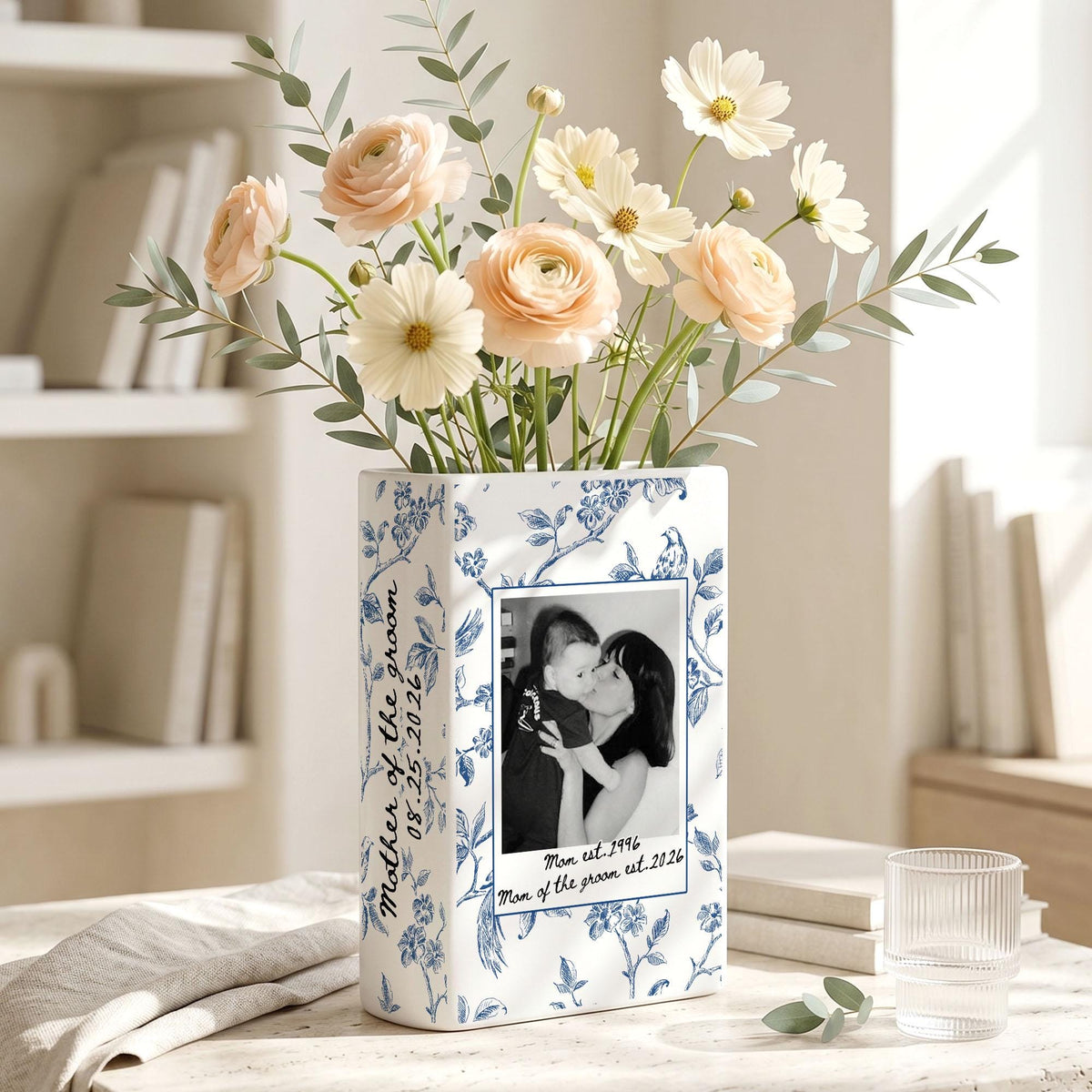 A rectangular white ceramic vase with a blue floral pattern, featuring a black and white photograph of a person holding a child. The text "Mother of the groom" and "08.25.2026" is printed on the side, with "Mom est. 1996" below the photo.