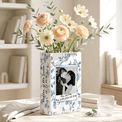 A rectangular white ceramic vase with a blue floral pattern, featuring a black and white photograph of a person holding a child. The text "Mother of the groom" and "08.25.2026" is printed on the side, with "Mom est. 1996" below the photo.