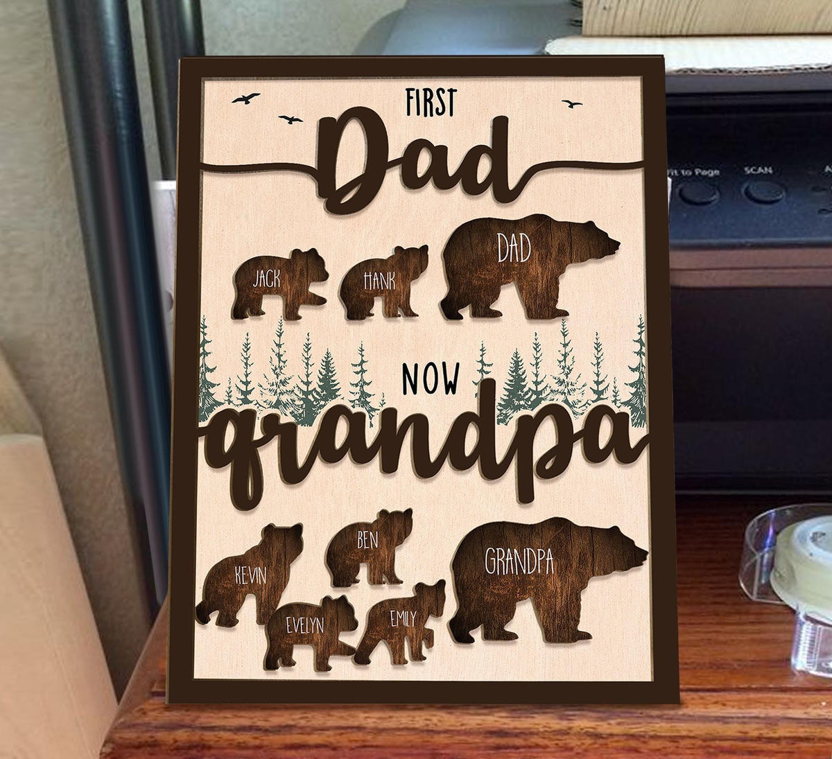 May include: A wooden sign with a brown background and a cutout design of bears. The sign reads "First Dad Now Grandpa" with the names of the children and grandchildren listed below the bears.