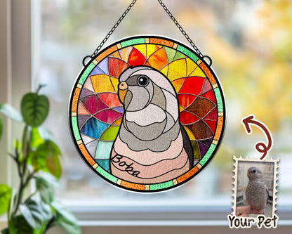 May include: A stained glass window hanging with a colorful design of a parrot with the name "Boz" written on it. The window is surrounded by a metal frame. A smaller image of a parrot is in the bottom right corner with the text "Your Pet".