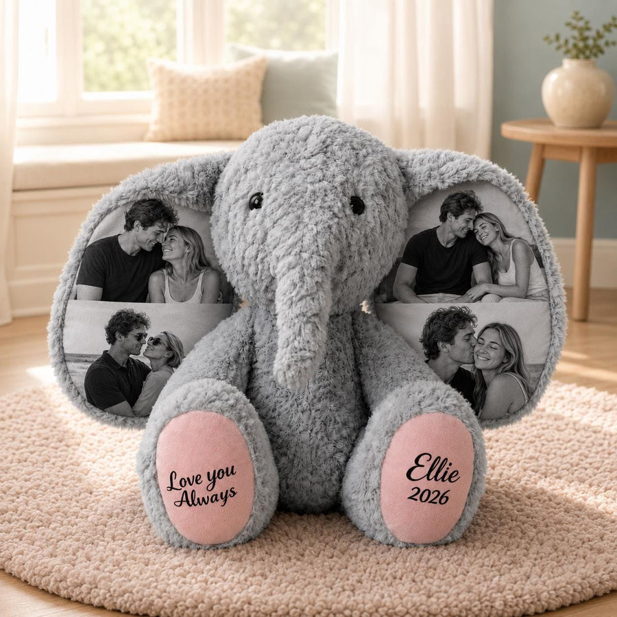 A gray plush elephant toy with large ears featuring printed black and white photographs of couples. The elephant has pink foot pads with the text "Love you Always" on the left foot and "Ellie 2026" on the right foot.