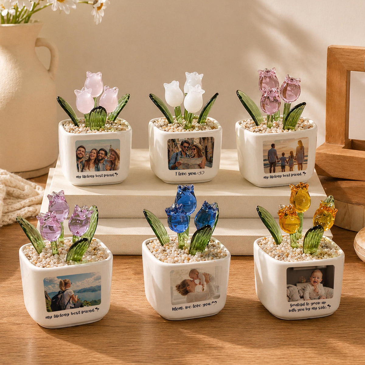 Six small, white ceramic pots, each with a different colored glass tulip arrangement. Each pot has a small photo and a quote. The tulips are pink, white, blue, and yellow. The quotes include "I love you" and "my lifelong best friend."