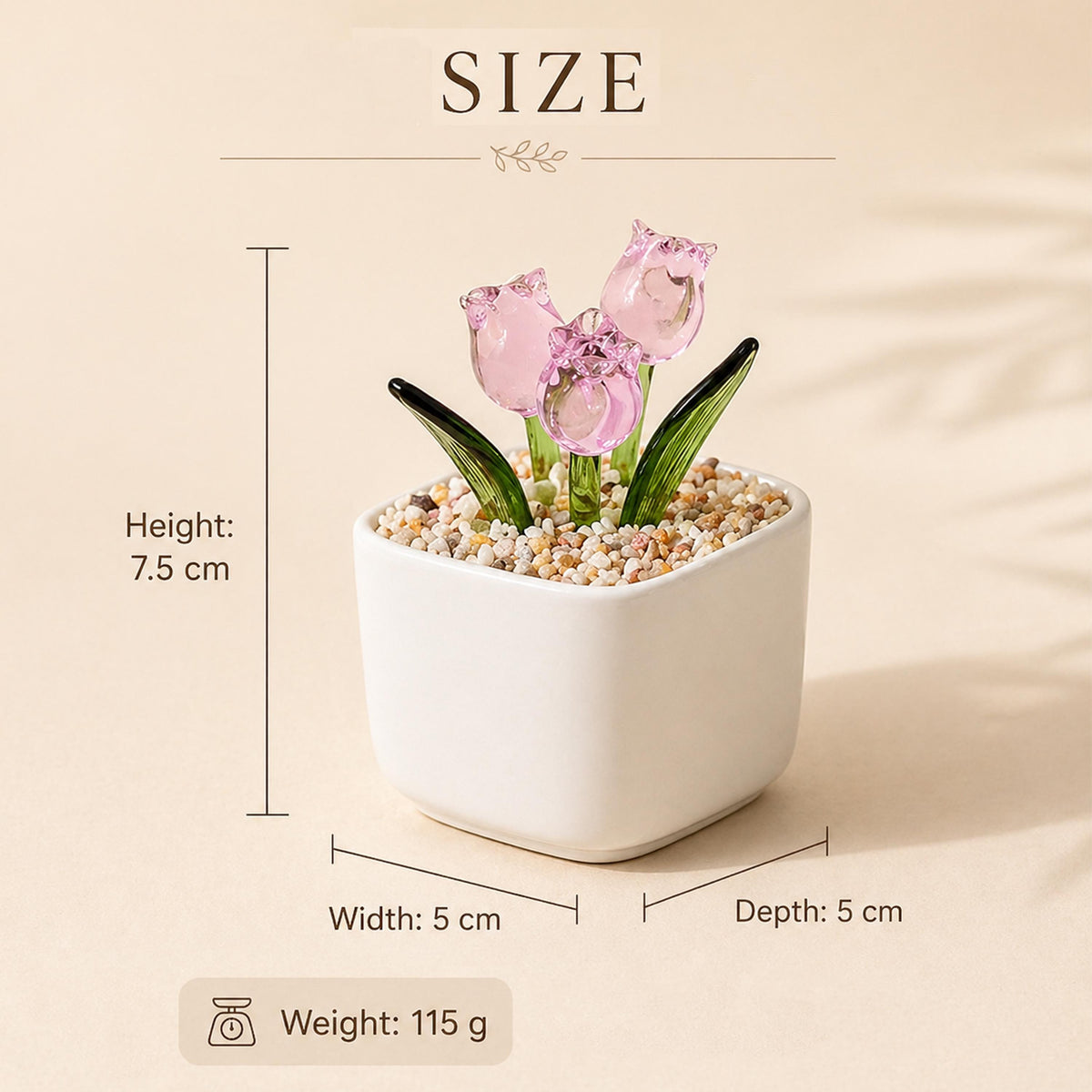 A small, white square ceramic pot with three pink glass tulip flowers and green leaves. The pot is filled with small pebbles. The height is 7.5 cm, width and depth are 5 cm, and the weight is 115 g.