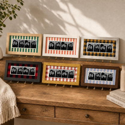 Six rectangular wall-mounted photo frames with hooks, each featuring a unique fabric backing pattern including green stripes, red stripes, yellow plaid, black plaid, yellow gingham, and blue stripes, displaying black and white photo strips.