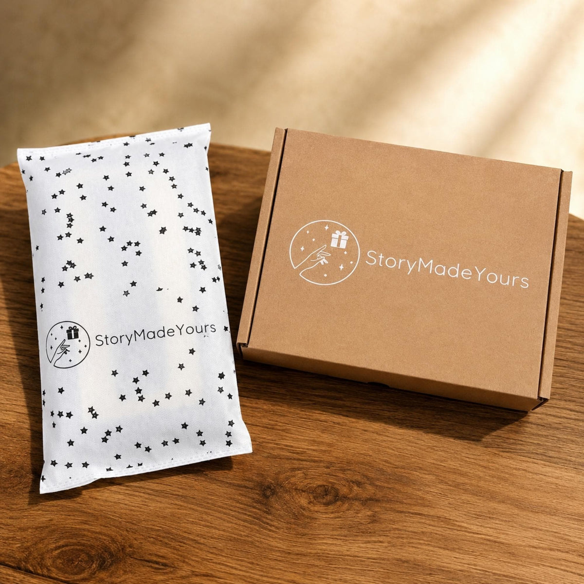 A rectangular brown cardboard shipping box and a white mailing bag with a black star pattern. Both items feature a white circular logo with a hand reaching toward a gift box and the text StoryMadeYours printed in a clean sans-serif font.