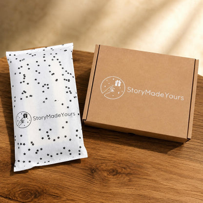 A rectangular brown cardboard shipping box and a white mailing bag with a black star pattern. Both items feature a white circular logo with a hand reaching toward a gift box and the text StoryMadeYours printed in a clean sans-serif font.