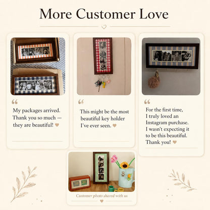 A collection of rectangular wooden photo frames with fabric borders in various patterns, including gingham and stripes. Some frames function as wall-mounted key holders with metal hooks, displaying multiple black and white photos.