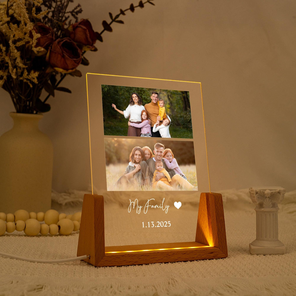 A personalized family photo night light. The rectangular acrylic panel displays two family photos and the text "My Family" with a heart symbol and the date 1.13.2025. The wooden base emits a warm glow.