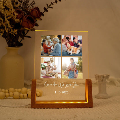 A lighted photo display with four family photos. The wooden base has a warm glow, and the text "Grandpa We Love You" and the date 1.13.2025 are illuminated on the front.