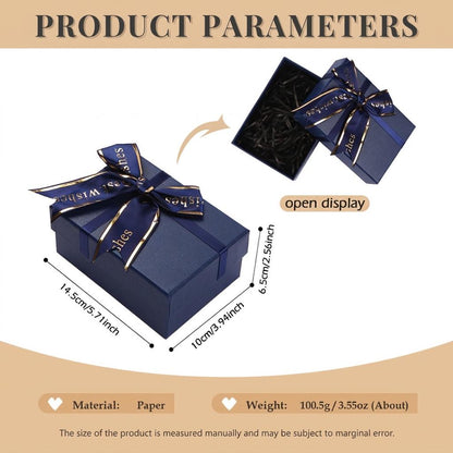 A dark blue rectangular paper gift box with a matching ribbon bow featuring the text 'best wishes' in gold. The box measures 5.71 inches by 3.94 inches by 2.56 inches. An open display view shows black paper filler inside the box.