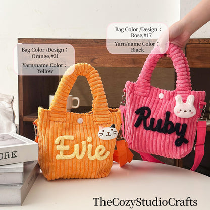 Two corduroy tote bags. One is orange with "Evie" in yellow, a cat face, and a yellow handle. The other is pink with "Ruby" in black, a bunny face, and a pink handle. Both have shoulder straps.