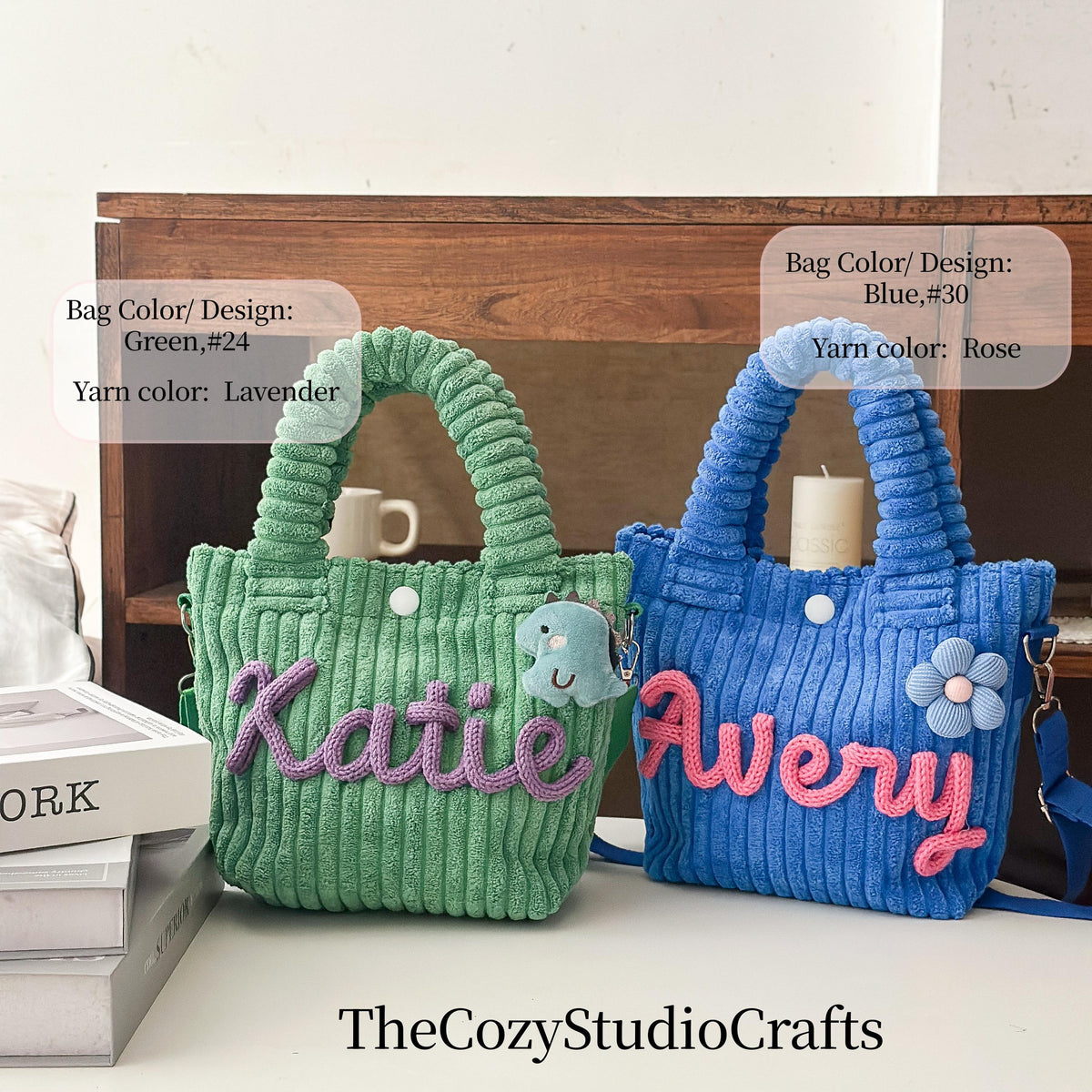 Two corduroy tote bags, one green with lavender yarn and the name "Katie", the other blue with rose yarn and the name "Avery". Each bag has a handle, a button, and a small charm. TheCozyStudioCrafts.