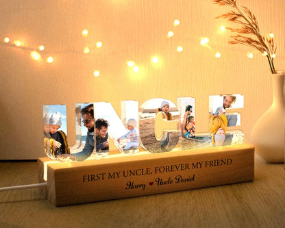 May include: A lighted wooden sign with the word "UNCLE" spelled out in clear acrylic letters. Each letter has a photo of a different person inside. The base of the sign has the text "First my uncle, forever my friend" and "Harry Uncle Daniel".