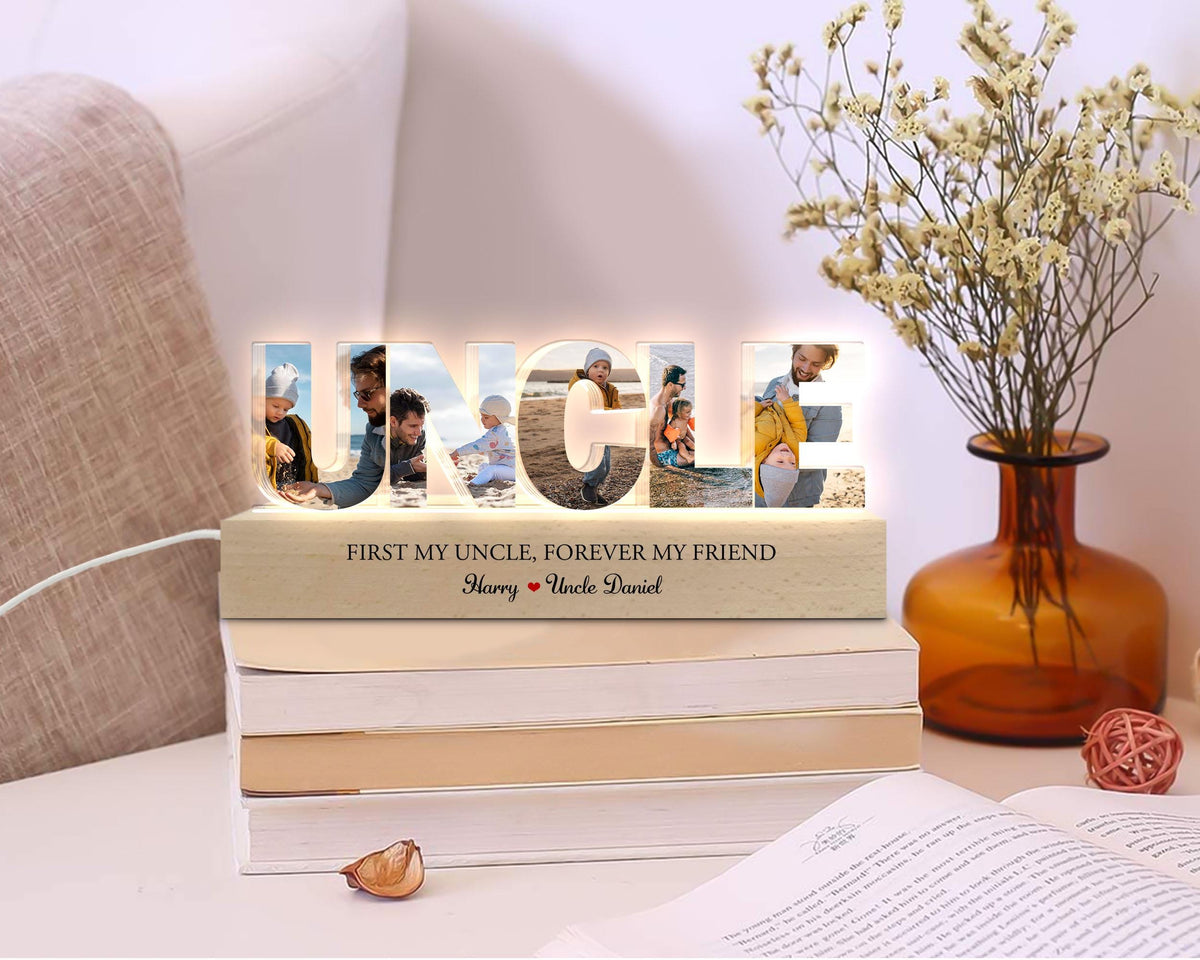 May include: A wooden light-up sign with the word "UNCLE" spelled out in large letters. Each letter has a photo of a person inside. The sign has a wooden base with the text "First my uncle, forever my friend" and the names "Harry" and "Uncle Daniel".
