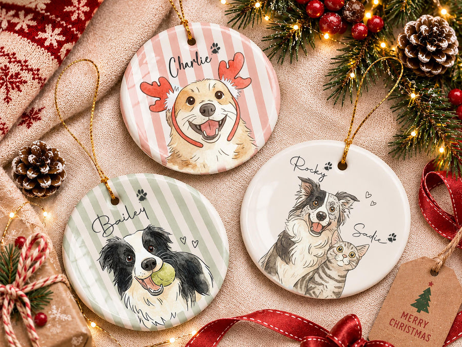 Three round ceramic ornaments featuring custom pet illustrations. One shows a corgi with reindeer antlers, one a border collie with a ball, and one a border collie and tabby cat. Each includes a gold hanging string and pet names.
