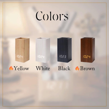 Four rectangular digital clocks with pen holder functionality, displayed in yellow, white, black, and brown wood-grain finishes. Each unit features a front-facing digital display showing the time, with the word Colors at the top.