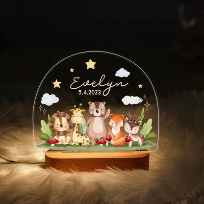 May include: A wooden night light with a clear acrylic insert featuring a whimsical woodland scene. The scene includes a lion, giraffe, bear, fox, and deer. The acrylic insert also features the name "Evelyn" and the date "5.4.2023".