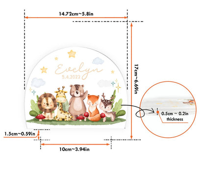 May include: A white, round, wooden sign with a watercolor illustration of a lion, giraffe, bear, fox, and deer. The sign has the name "Evelyn" and the date "5.4.2023" written in gold lettering. The sign measures 6.69 inches in diameter and 0.2 inches thick.